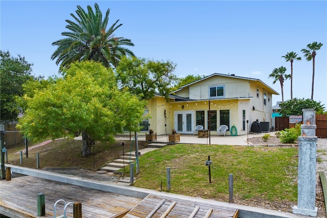 rear view of property with a wooden deck, french doors, and a patio area