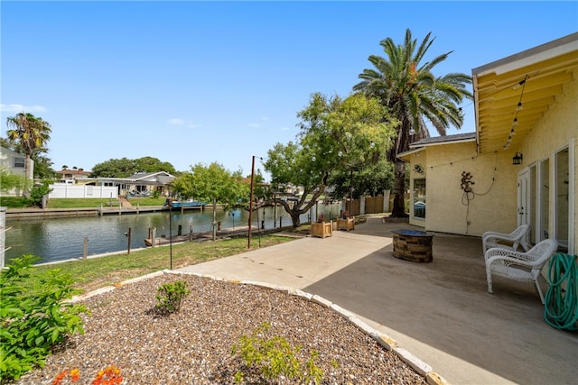 view of yard featuring a fire pit, a water view, and a patio