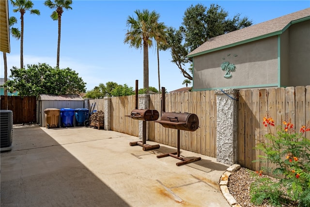 view of patio / terrace with cooling unit and a storage shed