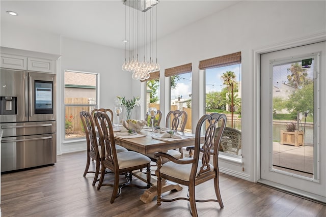 dining room featuring an inviting chandelier, a healthy amount of sunlight, and dark hardwood / wood-style floors