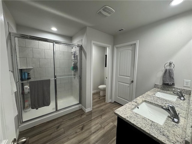 2682 Excelsior Blvd, Corpus Christi, TX 78415 - full bathroom with a stall shower, toilet, wood finished floors, double vanity, and recessed lighting