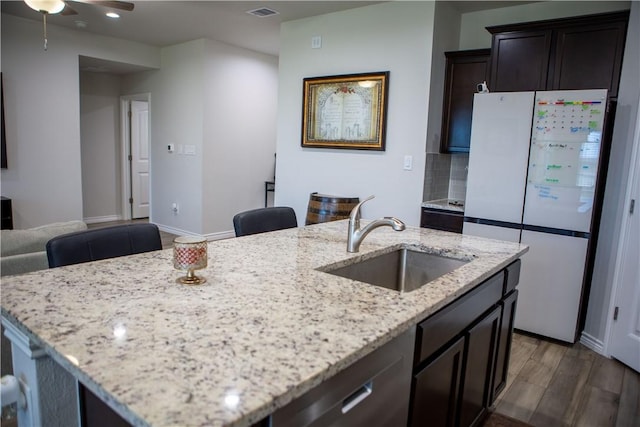 2682 Excelsior Blvd, Corpus Christi, TX 78415 - kitchen with freestanding refrigerator, a sink, a center island with sink, light stone countertops, and recessed lighting