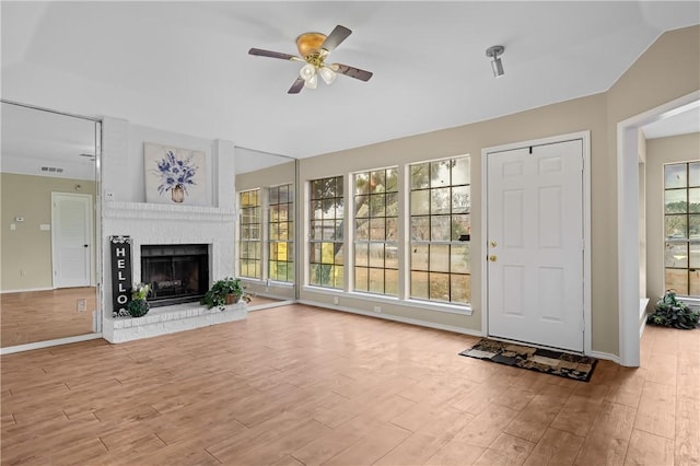 unfurnished living room with light hardwood / wood-style flooring, a fireplace, and a wealth of natural light