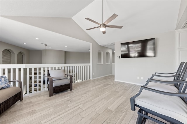 living area featuring light hardwood / wood-style floors, lofted ceiling, and ceiling fan