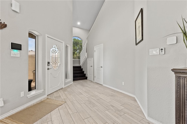 entryway featuring light wood-type flooring and a high ceiling