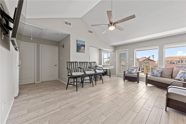 living room with ceiling fan, light hardwood / wood-style flooring, and vaulted ceiling