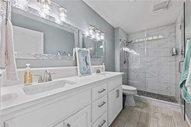 bathroom featuring toilet, vanity, an enclosed shower, and hardwood / wood-style flooring