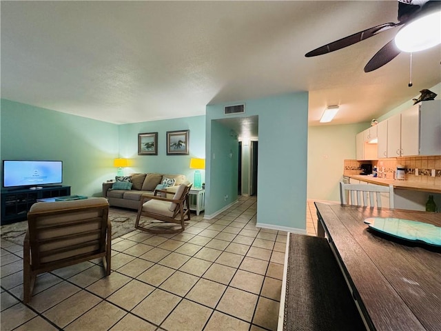 living room featuring ceiling fan and light tile patterned flooring