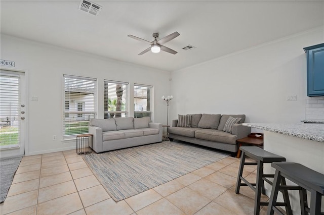 tiled living room featuring ceiling fan, a healthy amount of sunlight, and ornamental molding