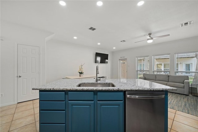 kitchen with sink, dishwasher, blue cabinets, and an island with sink