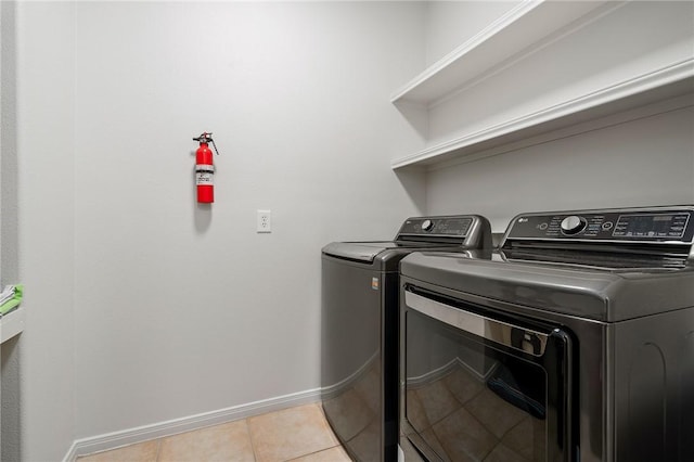 laundry area featuring light tile patterned floors and washer and clothes dryer