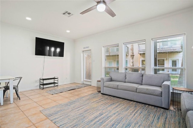 tiled living room with ceiling fan and ornamental molding