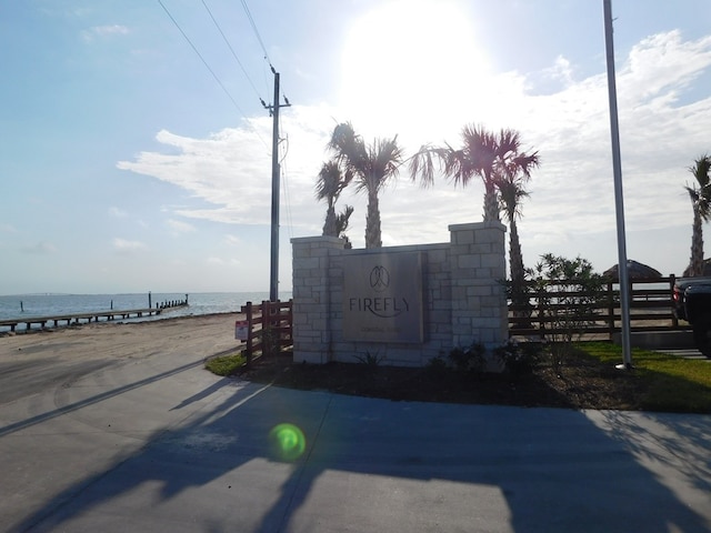 community sign featuring a water view