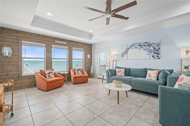 630 Copano Cv, Rockport, TX 78382 - living area featuring light tile patterned floors, a raised ceiling, wood walls, and a ceiling fan