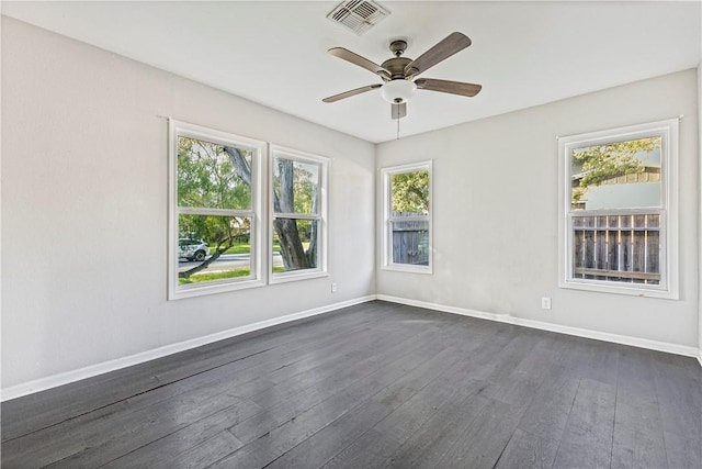 unfurnished room with baseboards, a ceiling fan, dark wood finished floors, and visible vents