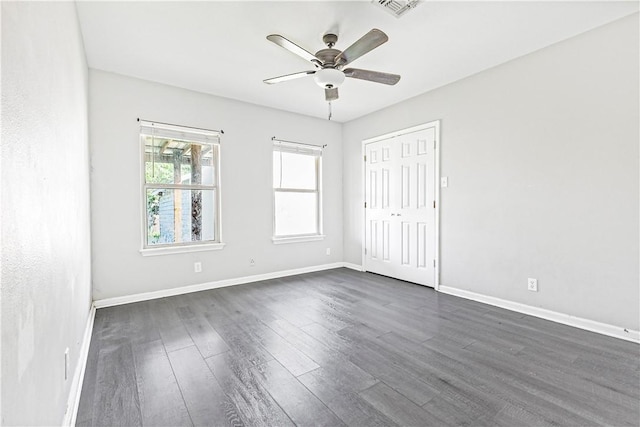 unfurnished bedroom featuring dark wood-style flooring, a ceiling fan, baseboards, visible vents, and a closet