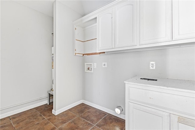 clothes washing area with hookup for a washing machine, cabinet space, hookup for an electric dryer, and dark tile patterned flooring