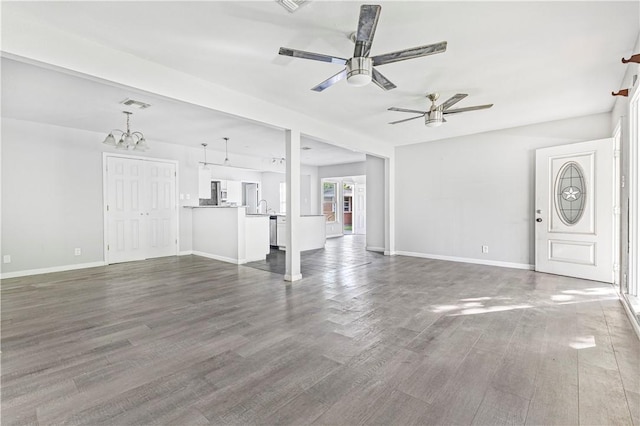 unfurnished living room featuring dark wood-style flooring, a sink, ceiling fan with notable chandelier, baseboards, and visible vents
