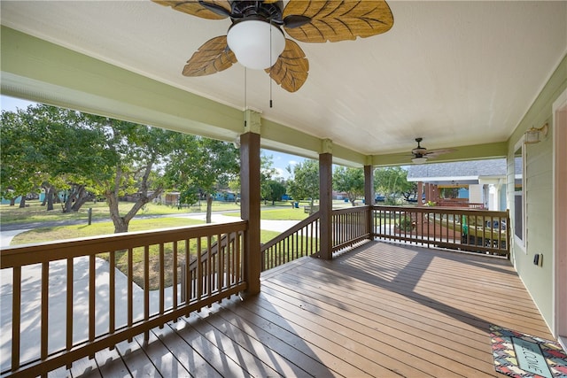 wooden deck featuring ceiling fan and a lawn