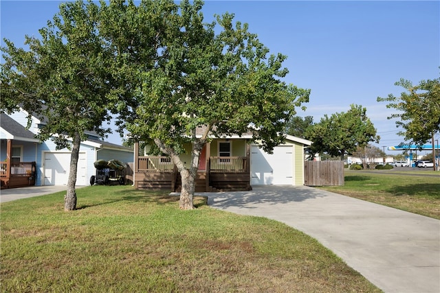 view of property hidden behind natural elements featuring a garage, a front yard, and a porch