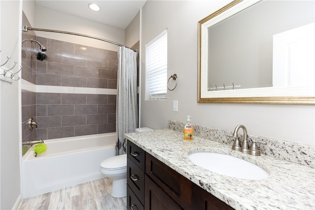 full bathroom featuring shower / bath combo with shower curtain, wood-type flooring, vanity, and toilet