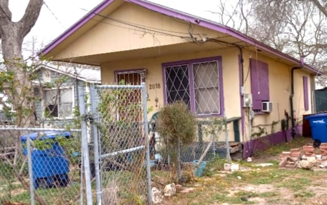 bungalow with fence and stucco siding