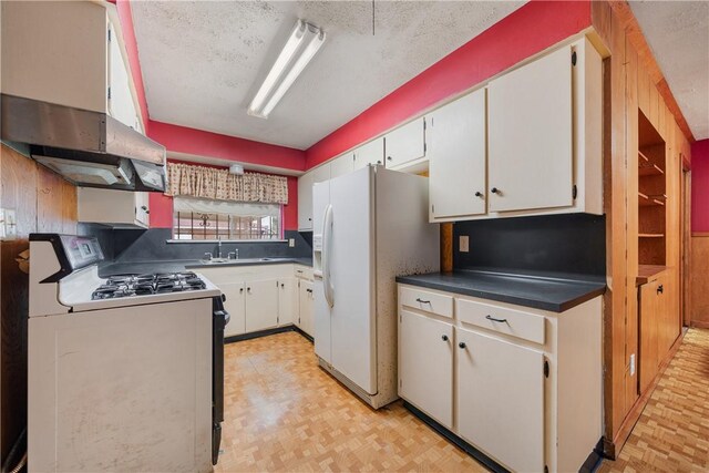 kitchen with sink, white cabinets, and white appliances