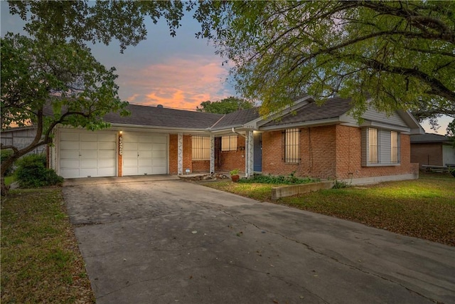 ranch-style home with a yard and a garage