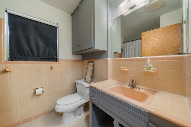 bathroom with tile patterned flooring, vanity, tile walls, and toilet