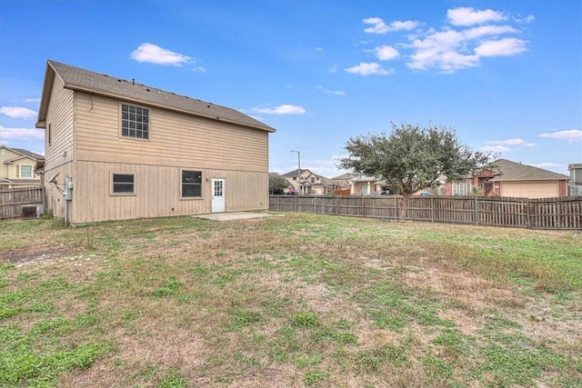 back of house featuring a yard, cooling unit, a fenced backyard, and a residential view