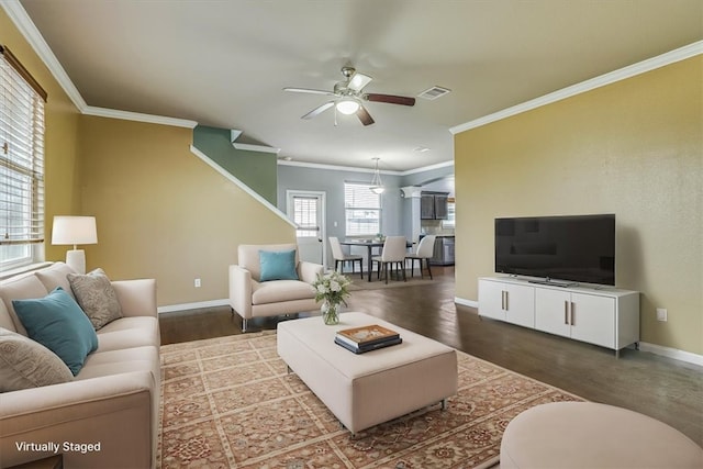 living area featuring visible vents, ornamental molding, ceiling fan, wood finished floors, and baseboards