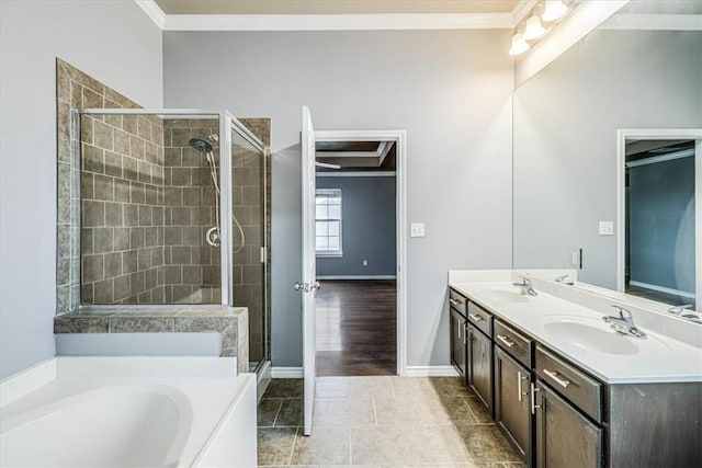 bathroom with double vanity, ornamental molding, a sink, and a bath