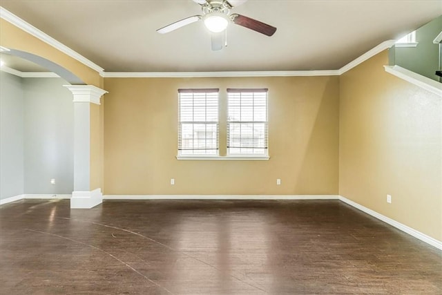 spare room with arched walkways, crown molding, decorative columns, ceiling fan, and baseboards