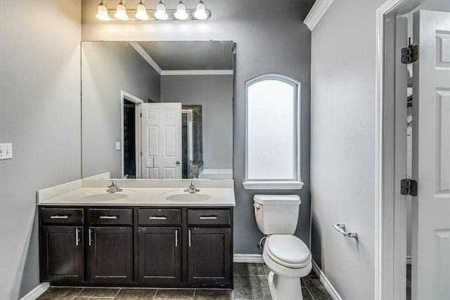 full bath with double vanity, ornamental molding, a sink, and toilet