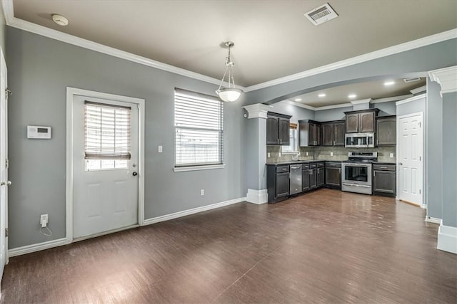 kitchen featuring tasteful backsplash, appliances with stainless steel finishes, pendant lighting, and baseboards