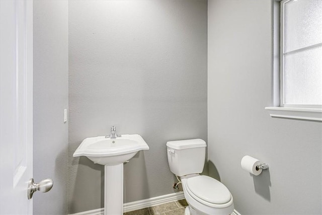 bathroom with toilet and baseboards