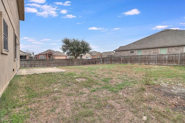 view of yard featuring a residential view, a fenced backyard, and a patio