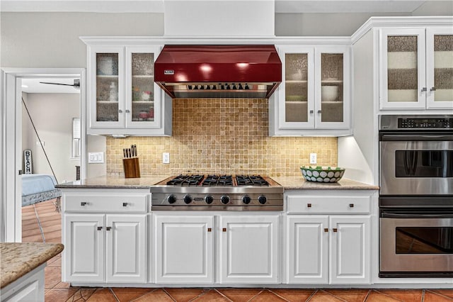 973 Pompano Dr, Aransas Pass, TX 78336 - kitchen featuring stainless steel appliances, custom exhaust hood, white cabinetry, and backsplash