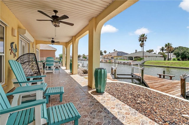 973 Pompano Dr, Aransas Pass, TX 78336 - view of patio / terrace with a water view, a dock, a ceiling fan, outdoor dining area, and boat lift