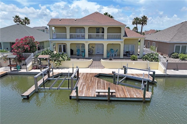 973 Pompano Dr, Aransas Pass, TX 78336 - rear view of house with boat lift, a water view, a patio, and a balcony