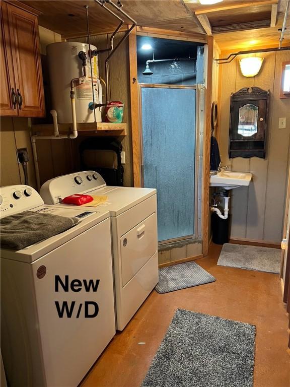 washroom with laundry area, water heater, and separate washer and dryer