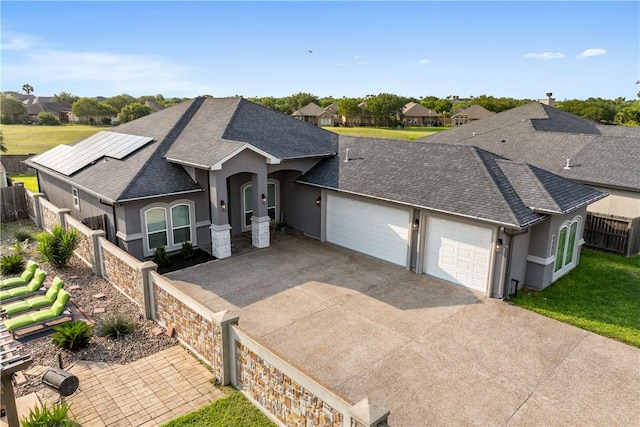 6421 Aikman, Corpus Christi, TX 78414 - ranch-style home featuring a garage, stucco siding, a shingled roof, driveway, and solar panels