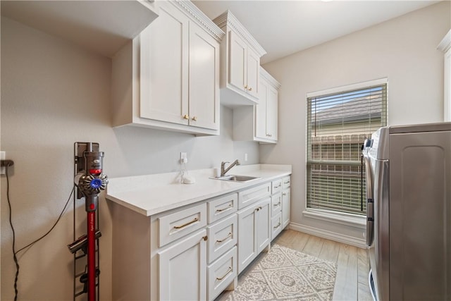 6421 Aikman, Corpus Christi, TX 78414 - kitchen with washer / clothes dryer, a sink, light countertops, and white cabinets