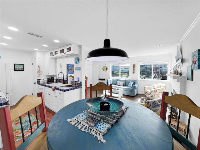 dining space with recessed lighting, wood finished floors, and visible vents