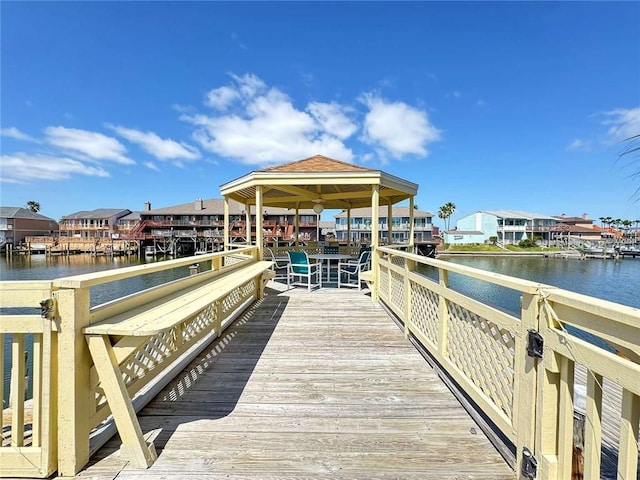 view of dock featuring a gazebo, a water view, and a residential view
