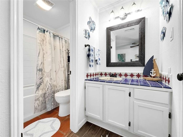 bathroom featuring vanity, ornamental molding, shower / bathtub combination with curtain, and toilet