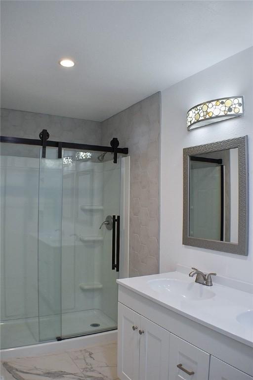 1517 E Warren Ave, Kingsville, TX 78363 - full bath featuring double vanity, a sink, marble finish floor, and a stall shower
