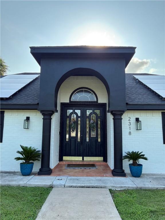 2318 Flushing, Weslaco, TX 78596 - entrance to property with roof with shingles and brick siding