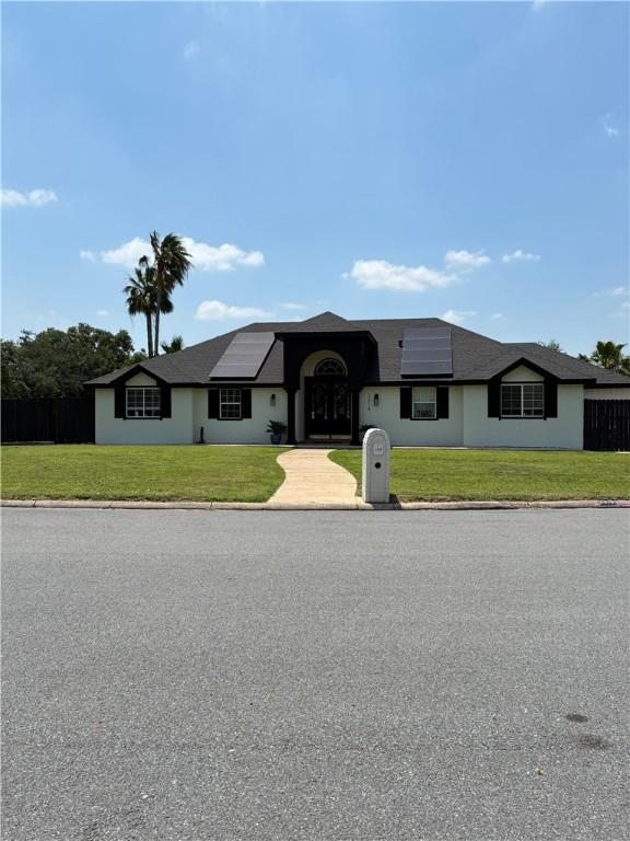 2318 Flushing, Weslaco, TX 78596 - view of front of home with roof mounted solar panels and a front yard