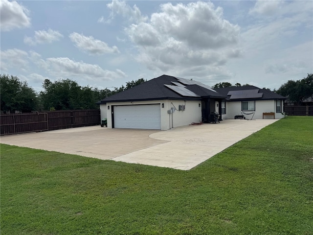 rear view of house featuring roof mounted solar panels, stucco siding, driveway, and an attached garage